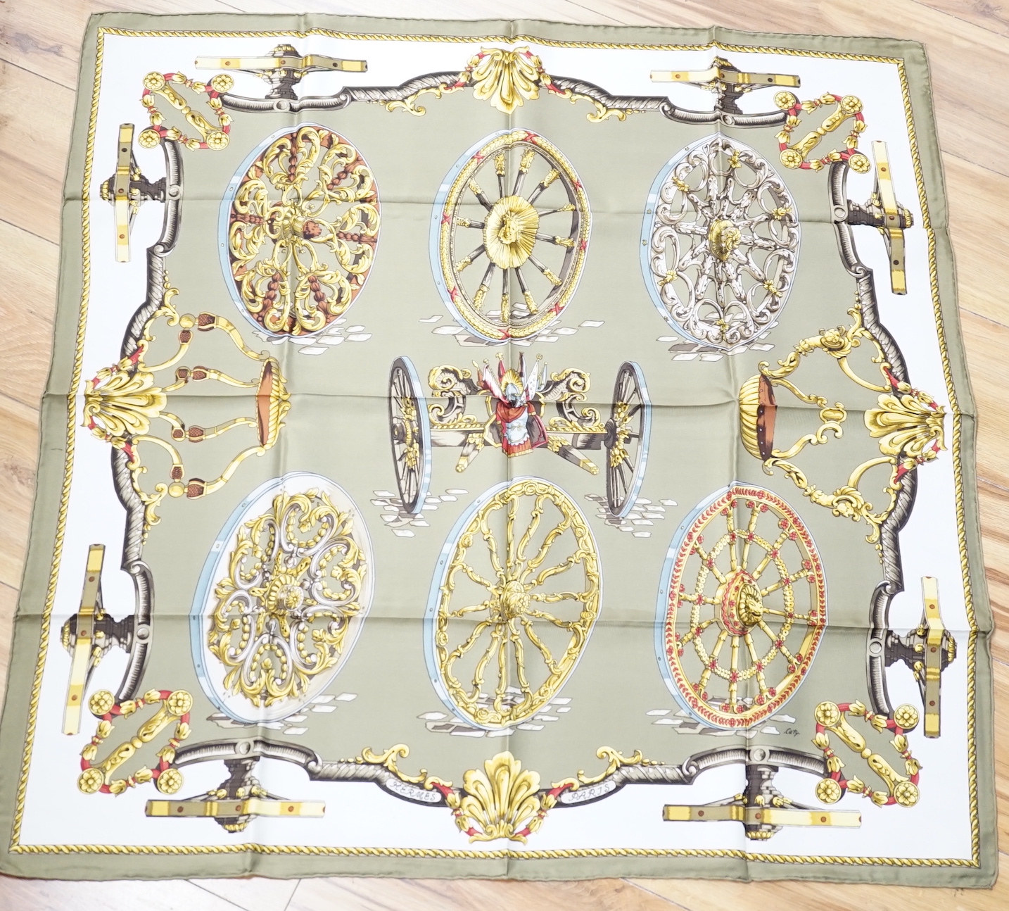 Four vintage Hermes silk scarves including one retailed by Harrods comprising, Selles A Housse, Roues de Canon, Passementerie and a rectangular Brides de Gala example